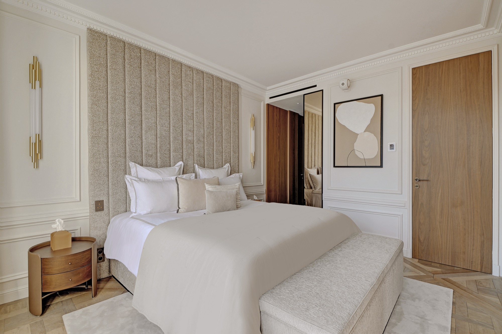 Chambre hôtelière avec linge blanc et parquet chevron — bail mobilité Paris Ginta