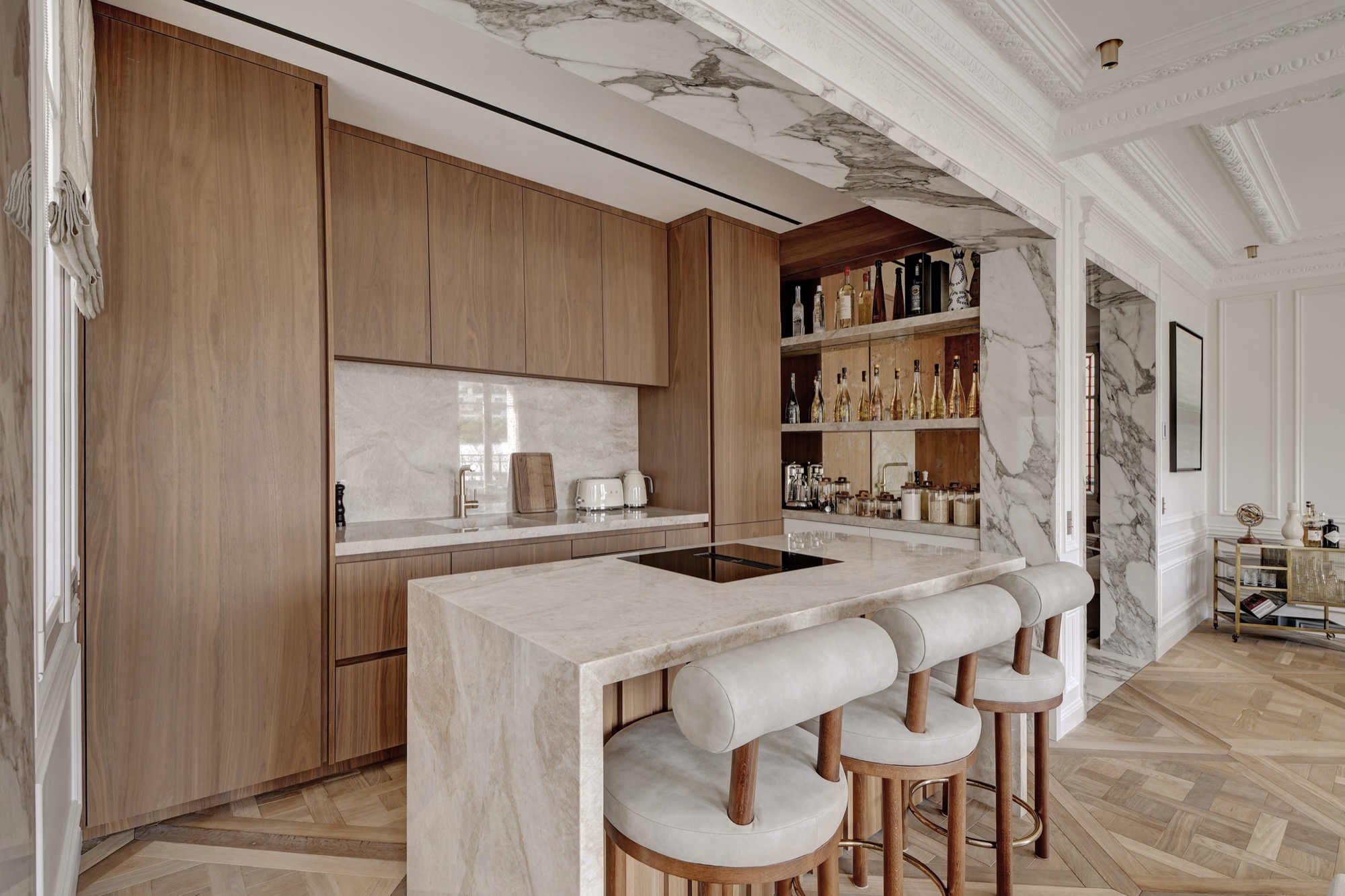Cuisine ouverte avec îlot en marbre et bar à alcools — appartement Paris location courte durée