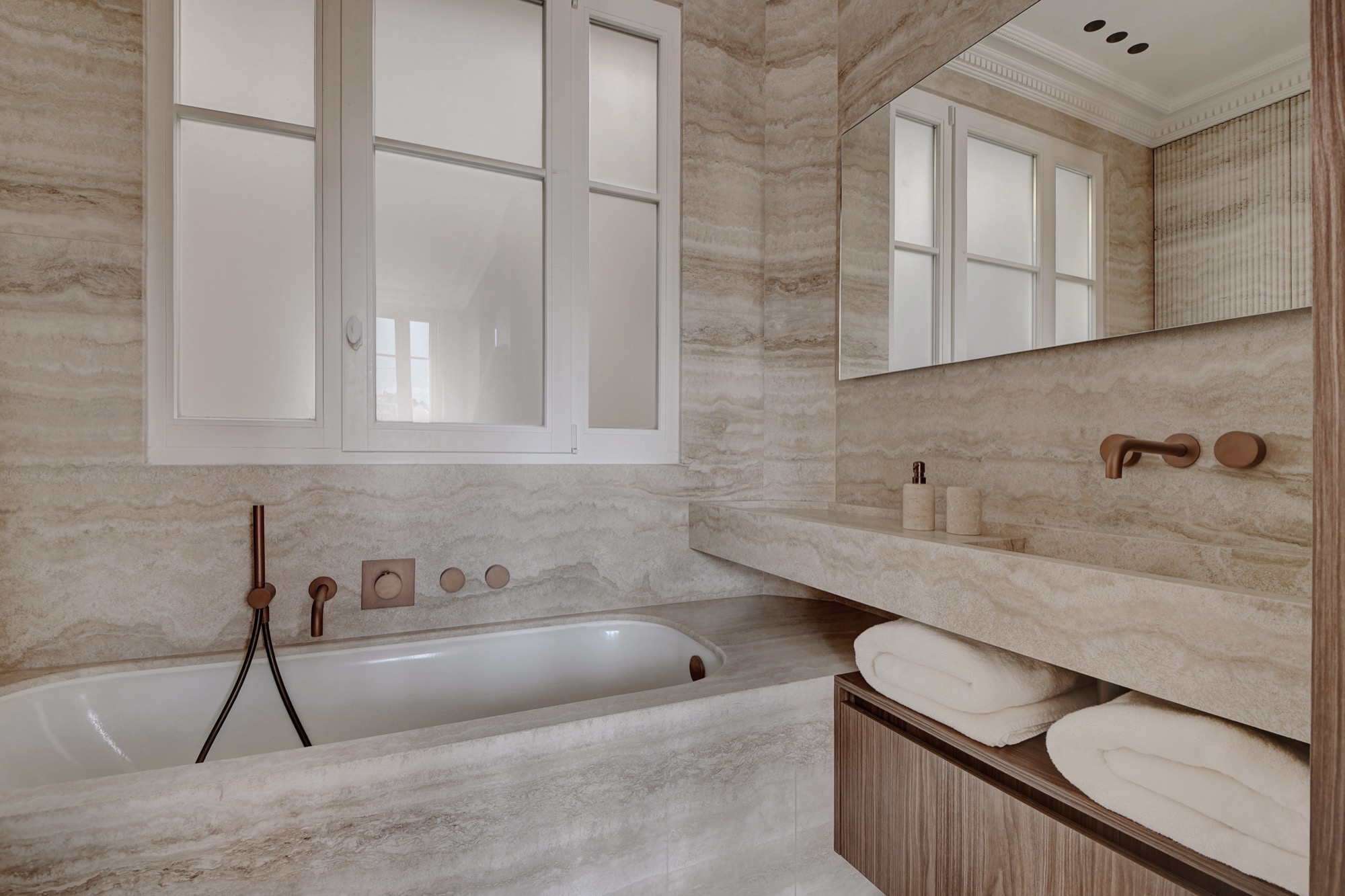 Salle de bain en travertin avec baignoire encastrée — appartement premium Paris